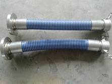 Two straight chemical composite hose are on the ground, with a flange on one end and a clamp on the other end.